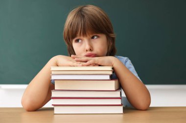 Okula dönelim. Ahşap masadaki çocuk içeride tahtaya karşı.