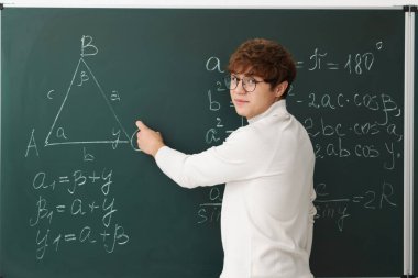 Okula dönelim. Öğrenci içeride karatahta üzerinde matematik yapıyor.