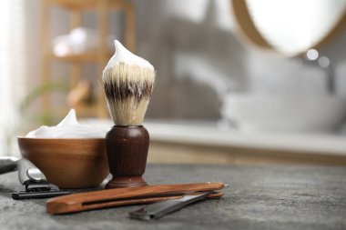 Tıraş fırçası, köpük ve tıraş bıçakları kapalı alanda gri desenli masa, yazı için yer ile yakın çekim. Berber aletleri.