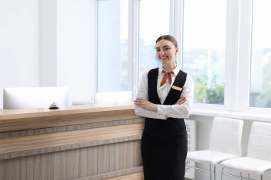 İçerideki resepsiyonda üniformalı mutlu resepsiyonist.