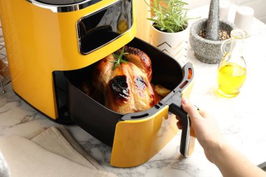 Beyaz mermer masada tavuk ve sebze pişiren kadın, yakın plan.