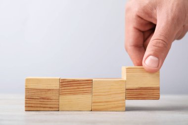 Hafif arka planda tahta küpleri olan adam, yakın plan. Metin için boşluk