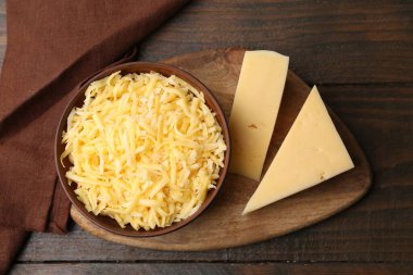 Tahta masanın üstünde rendelenmiş ve peynir parçaları, üst manzara.