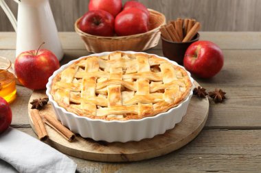 Lezzetli ev yapımı turta, taze elmalar, tarçın çubukları ve ahşap masada anason yıldızları, yakın plan.