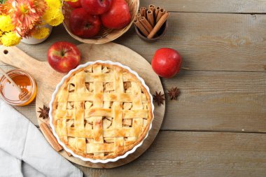 Lezzetli ev yapımı turta, taze elmalar, bal ve çiçekler ahşap masada, düz yatak. Metin için boşluk
