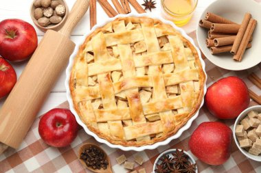Lezzetli ev yapımı turta, taze elmalar, yuvarlak iğne ve baharatlar beyaz ahşap masada, düz yatıyordu.
