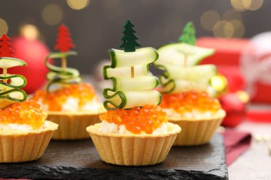 Gri masadaki lezzetli turtalar bulanık ışıklara karşı, yakın plan. Noel mezesi.