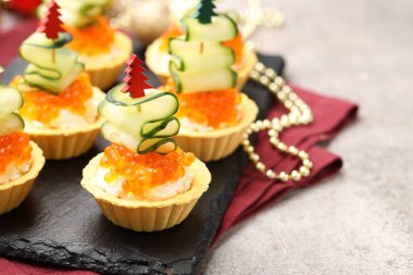 Gri desenli masada lezzetli tartlar, yakın plan. Noel mezesi.