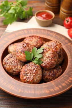 Ahşap masada servis edilen kızarmış köfteler, yakın plan.