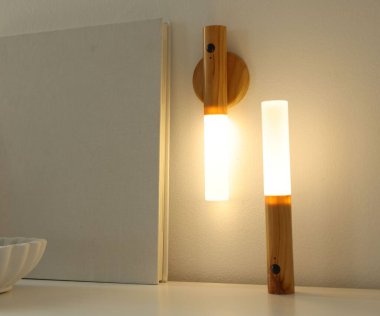 Evdeki beyaz masada taşınabilir LED lambalar ve dekor, yakın plan.