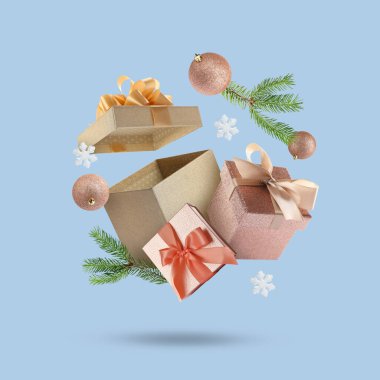 Noel ya da yeni yıl kutlaması. Hediye kutuları ve açık mavi arka planda uçan şenlikli dekor
