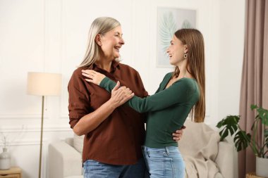 Anne ve kızı evde sarılıyor. Aile bağı