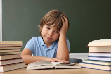 Okula dönelim. Çocuk masa başında karatahtaya karşı çalışıyor.