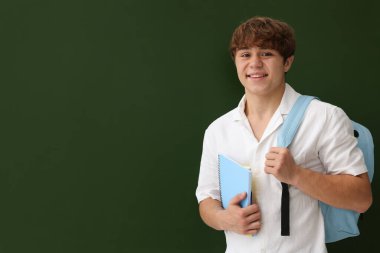 Okula dönelim. Sırt çantalı ve karatahtanın yanında defterleri olan öğrenci, metin için boşluk