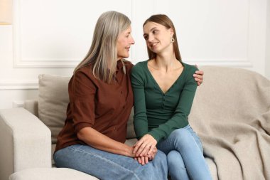 Anne ve kızı evde kanepede sarılma