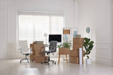 Taşınma günü. Mukavva kutular, bilgisayar ve mobilyalar ofiste.