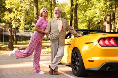 Modern Cabriolet yakınlarında şık bir yaşlı çift.