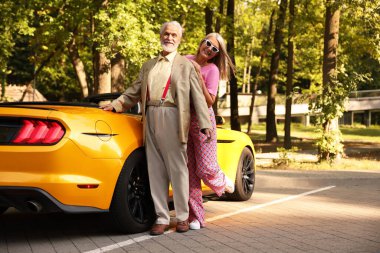 Modern Cabriolet yakınlarında şık bir yaşlı çift.