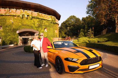 Modern Cabriolet yakınlarında güneş gözlüklü şık bir çift.