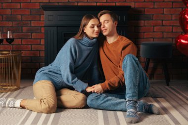 Oda da şöminenin yanında güzel bir çift var.