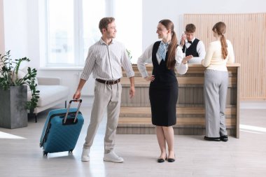 Oteldeki resepsiyonist misafiri karşılıyor.