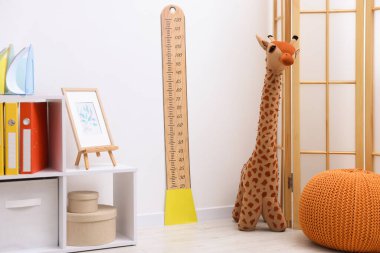 Boy ölçüm tablosu, oyuncak zürafa ve dekorasyon.