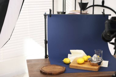 Stüdyoda kamerayla taze limon ve meyve sıkacağı çekmek, mesaj için yer açmak. Profesyonel yemek fotoğrafçılığı.