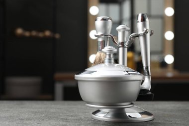 Berber dükkanında gri desenli masa üzerinde berber aletleri olan metal standı, yakın plan. Metin için boşluk