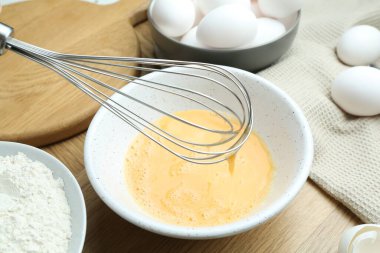 Tahta masada çırpılmış yumurta, çırpılmış çırpılmış un, yakın plan.