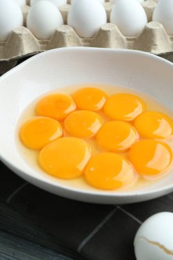 Çiğ yumurta ve yumurta sarısı masada, yakın plan.