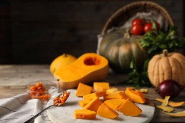 Taze balkabakları, tohumlar, kabuklar ve malzemeler ahşap masada, yakın plan.