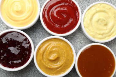 Gri masadaki tabakta farklı lezzetli soslar var.