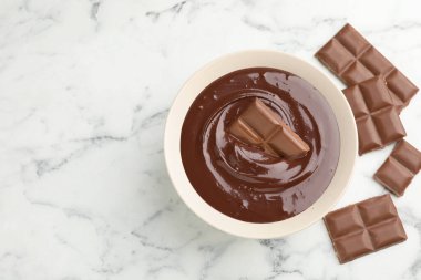 Erimiş çikolata ve parçalar beyaz mermer masada, düz yerde. Metin için boşluk