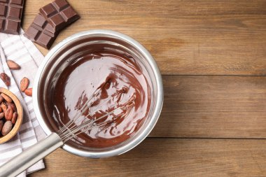 Kavanozda çırpılmış çikolata, ahşap masada fasulye parçaları, düz yatak. Metin için boşluk