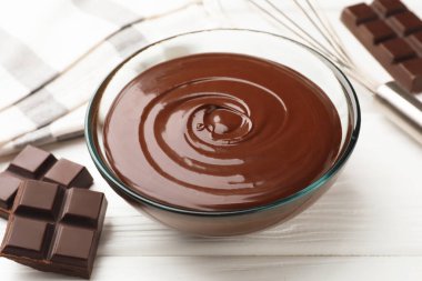 Erimiş çikolata, çırpılmış çırpılmış ve parçalanmış beyaz tahta masa, yakın plan.