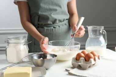Beyaz masada hamuru hazırlayan kadın, yakın plan.
