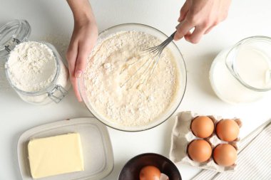 Beyaz masada hamuru yapan kadın (sıvı hamur), üst görünüm