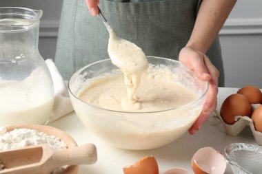 Beyaz masada hamuru hazırlayan kadın, yakın plan.