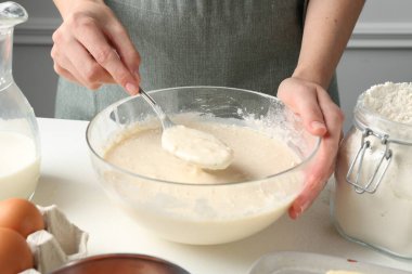 Beyaz masada hamuru hazırlayan kadın, yakın plan.