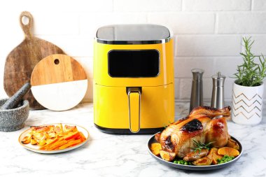 Lezzetli ızgara tavuk biberiyeli, sebzeli ve beyaz mermer masada kızartma makinesi.