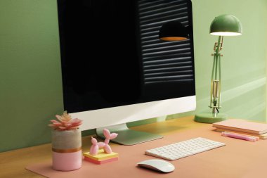 Ofisinde bilgisayar ve pembe hasırlı şık bir iş yeri, yakın plan.