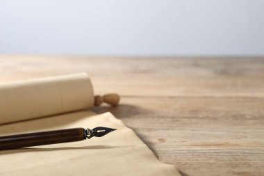 Eski kağıt parşömen ve dolmakalem ahşap masada, yakın plan.