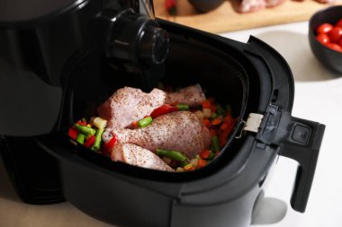 Çiğ tavuk budu ve sebzeli kızartma makinesi, yakın plan.