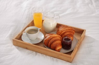 Otel odasındaki yatakta nefis bir kahvaltı tepsisi, yakın plan.