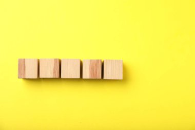 Sarı arka planda ahşap küpler, üst manzara