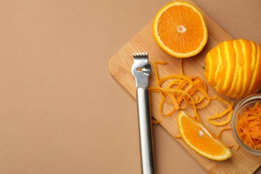 Turuncu tat, taze meyve ve bej arka planda zester aracı, üst manzara. Metin için boşluk