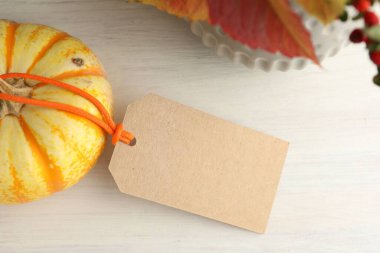 Boş kart, balkabağı ve sonbahar kompozisyonu beyaz ahşap masada, düz yerde. Tasarım için model