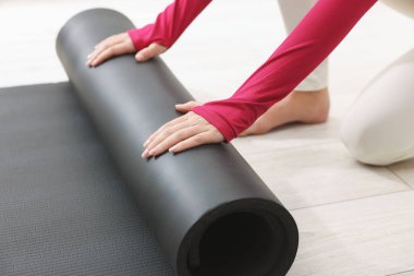 Yoga stüdyosunda hasırları açan kadın, yakın çekim.