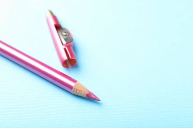 Açık mavi arka planda göz kalemi ve keskinleştirici, yakın plan. Metin için boşluk