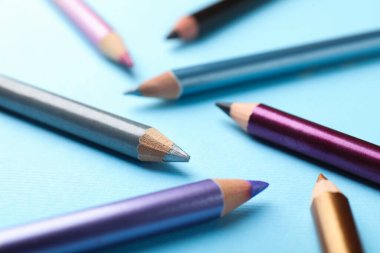 Açık mavi arkaplanda göz kalemleri, yakın plan.